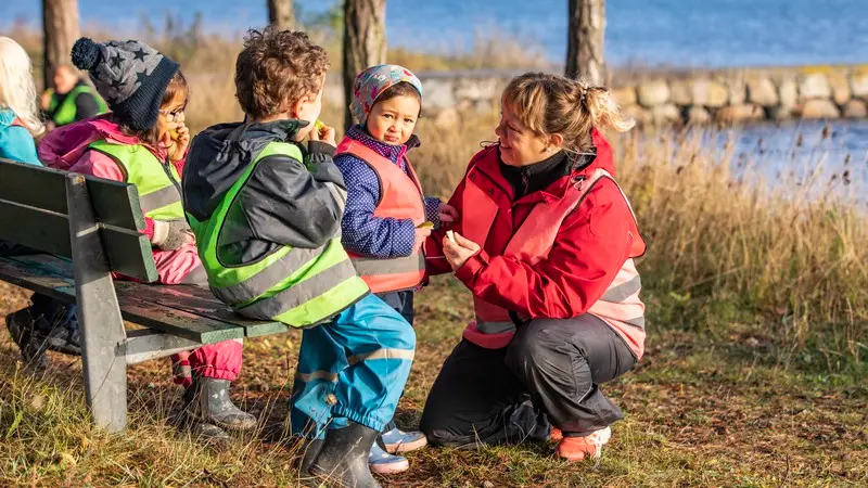 Lärare pratar med ett barn utomhus