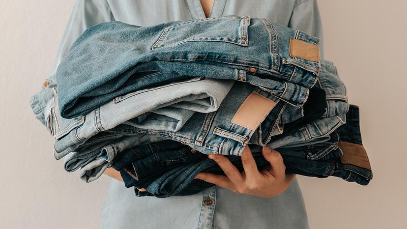 Person håller i begagnade jeans