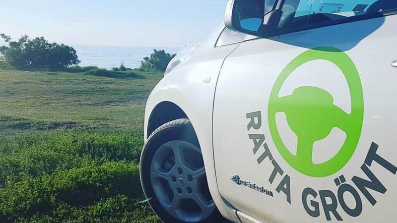 En vit lastbil parkerad på ett grönskande fält.