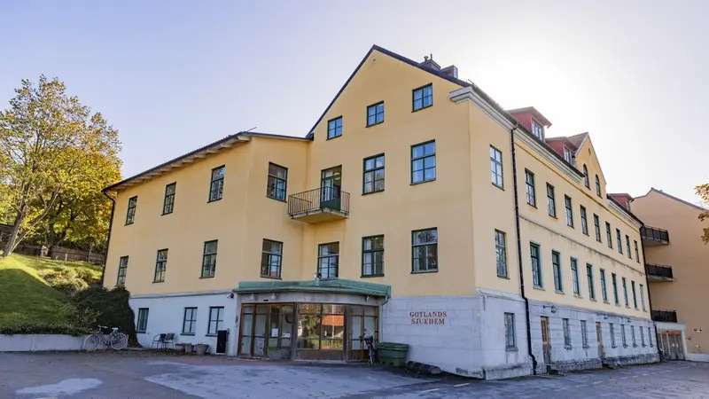 Entre till stor- gul trevåningsbyggnad