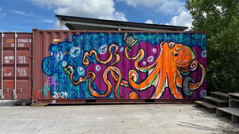 Container utsmyckad med en stor orange bläckfisk som källsorterar.