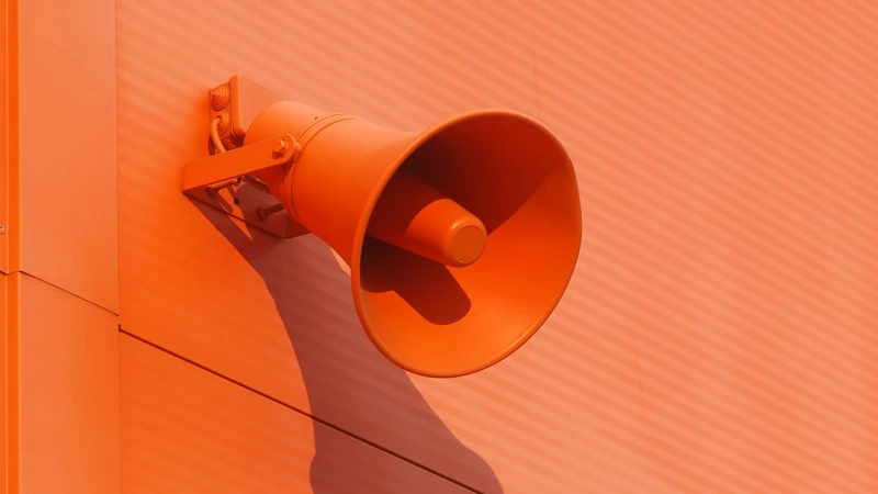En orange vägg med en högtalare ansluten till den.