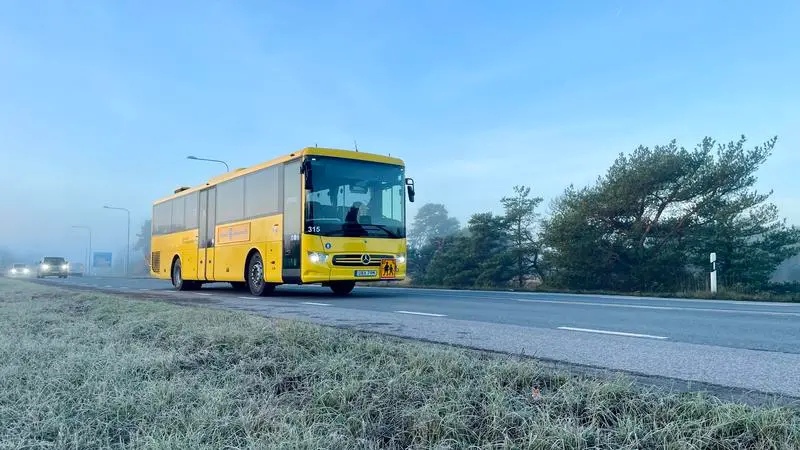En gul buss på landsväg.