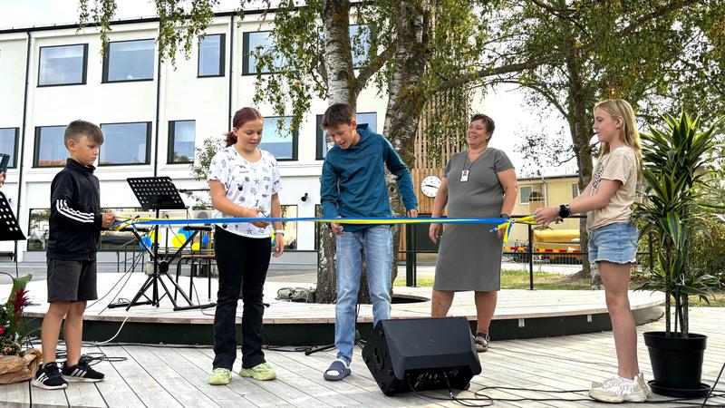 Fyra barn klipper band vid nya Alléskolan.