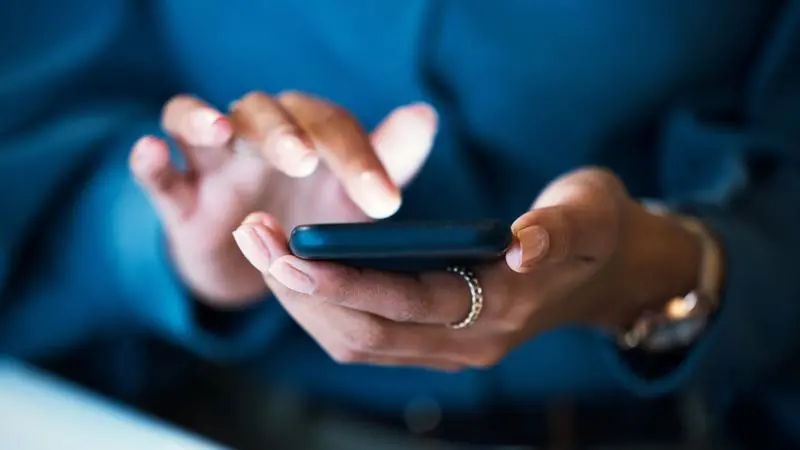 Kvinna som håller i en mobiltelefon
