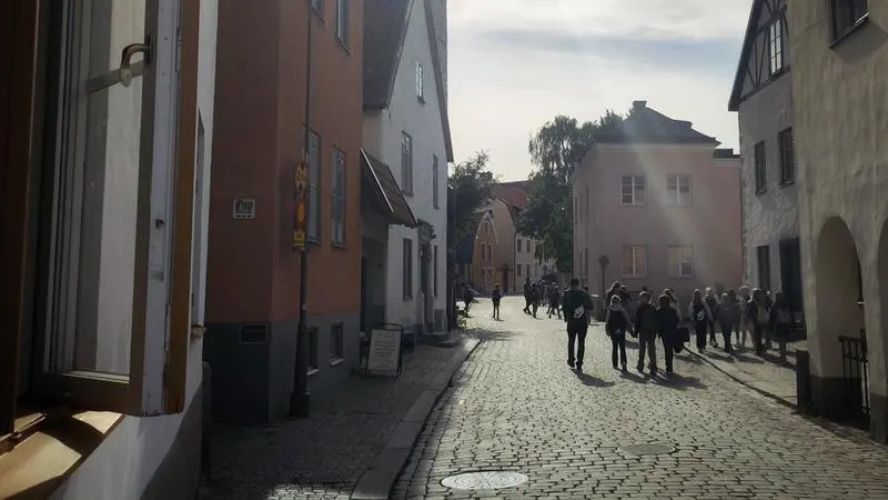 En solig eftermiddag i Visby, människor strosar längs kullerstensgatorna.