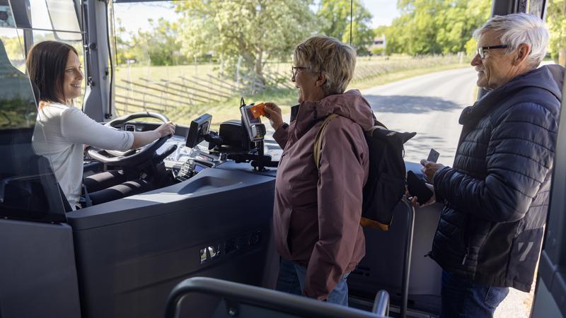 Två äldre människor går på en buss på Gotland