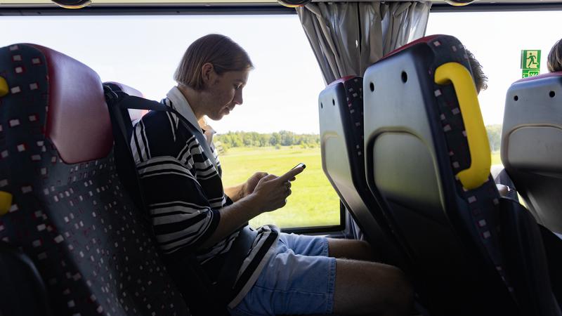 en ung kille som letar information på sin telefon