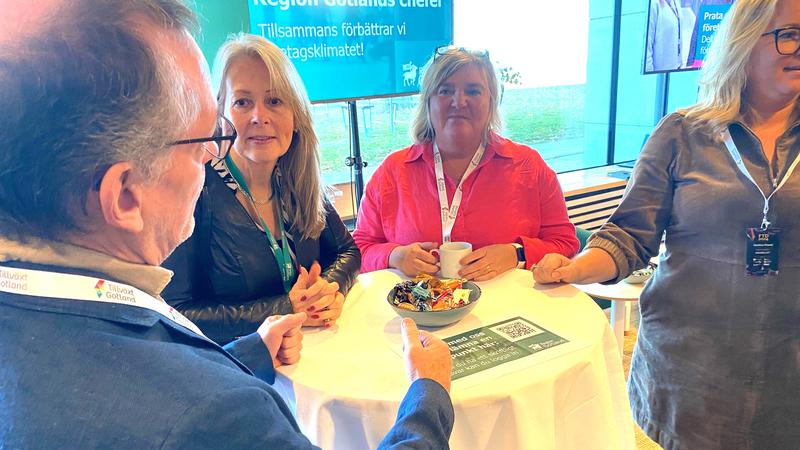 Fyra personer samtalar runt ett bord