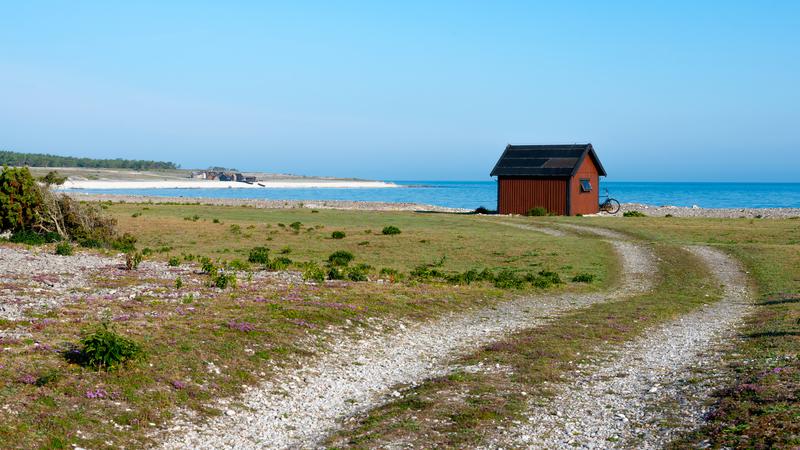 Röd fiskebod på stranden i Fårö