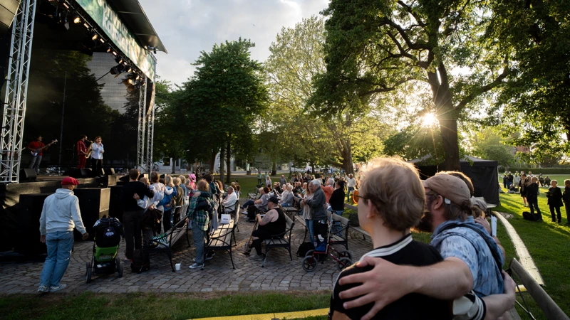 En grupp människor som står på framför en scen och håller om varandra.