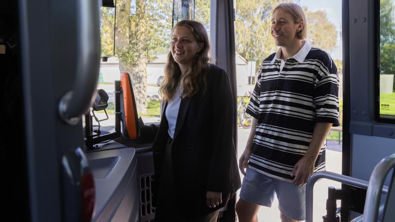 två ungdomar som går på bussen