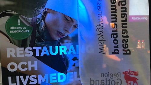 Belyst skylt i mörk lokal med texten restaurang och livsmedel