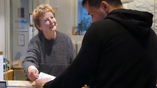 Kvinna tar emot en person i en reception