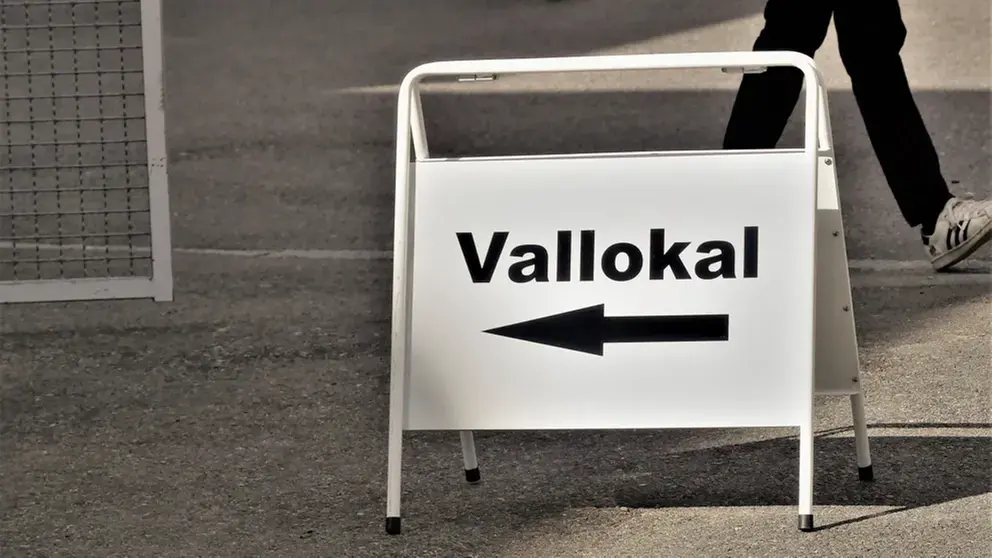 En vit skylt med texten "Vallokal". 