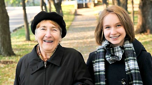Ung tjej och äldre dam på promenad