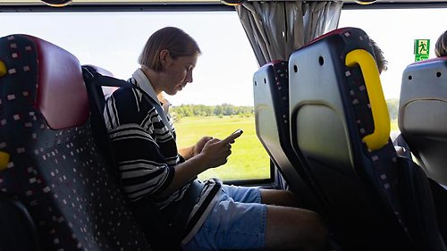 en ung kille som letar information på sin telefon